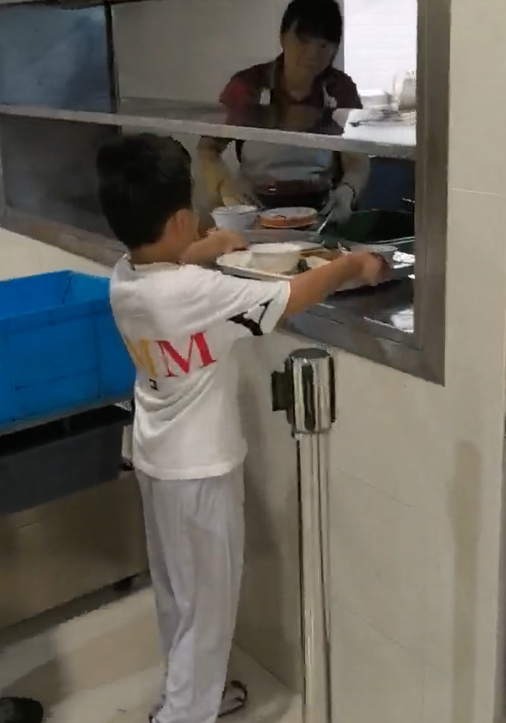 宸宸把用过的餐具放到回收区