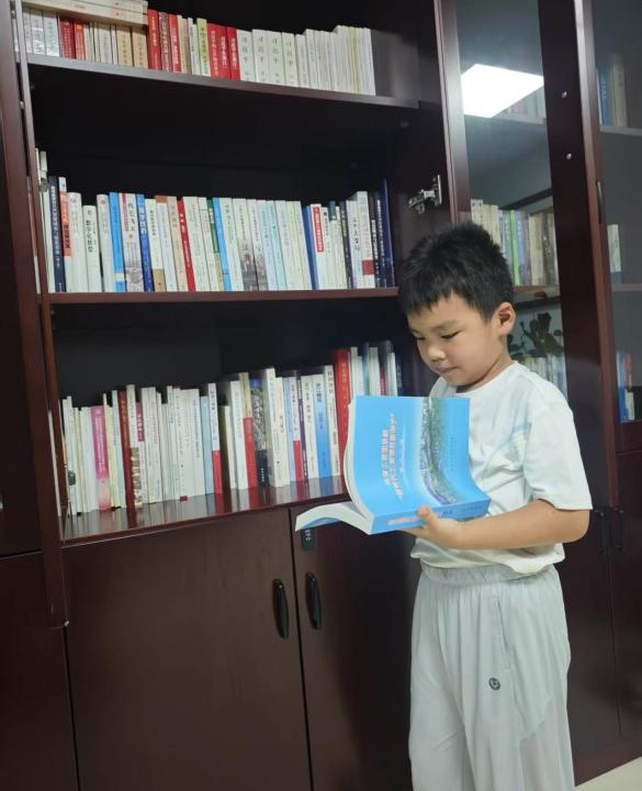宸宸在认真翻阅书柜里的书